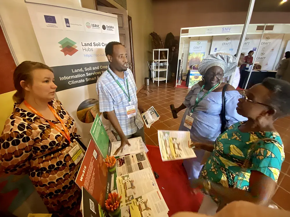 "Thaïsa van der Woude, ISRIC (left) and Jules Rutebuka, ICRAF (center) discuss the Land Soil Crop Hubs concept the Ugandan Ministry of Agriculture, Animal Industry and Fisheries (MAAIF) at the project’s ASARECA booth."