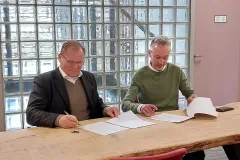 IFDC President and CEO Henk van Duijn sits next to ISRIC Director Rik van den Bosch while signing the new partnership agreement