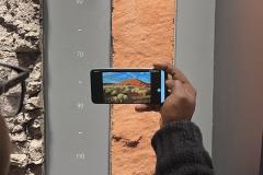 Person holding a mobile phone to scan a soil profile