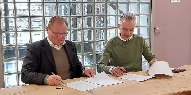 IFDC President and CEO Henk van Duijn sits next to ISRIC Director Rik van den Bosch while signing the new partnership agreement